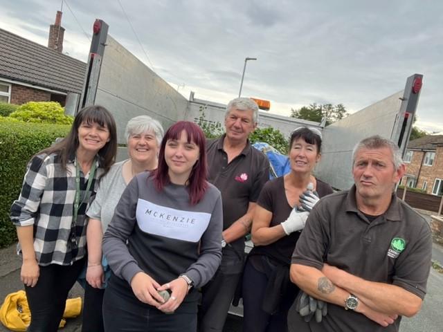 Staff volunteer their time to keep our neighbourhoods tidy. They post for a photo after a hard day weeding!